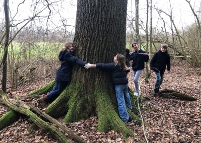 Naturforscher - Schüler:innen der Horizonta umarmen einen Baum