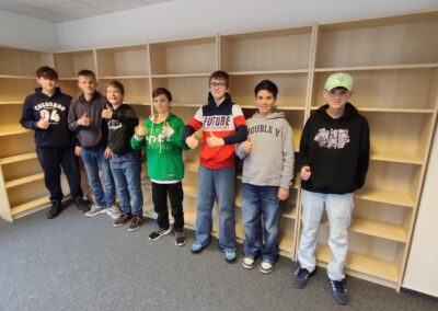 Gruppenbild der sieben Schüler der Abteilung Jestec vor den aufgebauten Regalen.